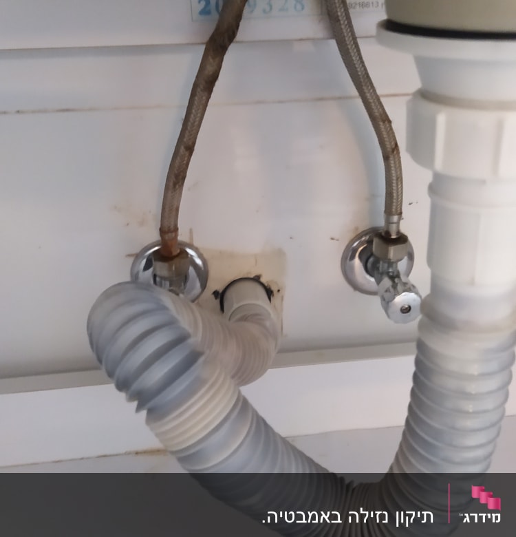 צינורות מתחת לכיור עם חיבורים וברזים